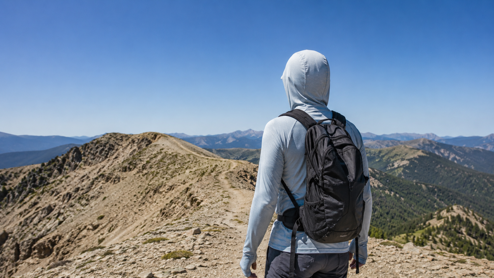 Sun hoodie with thumb loops on an exposed summer hiking trail