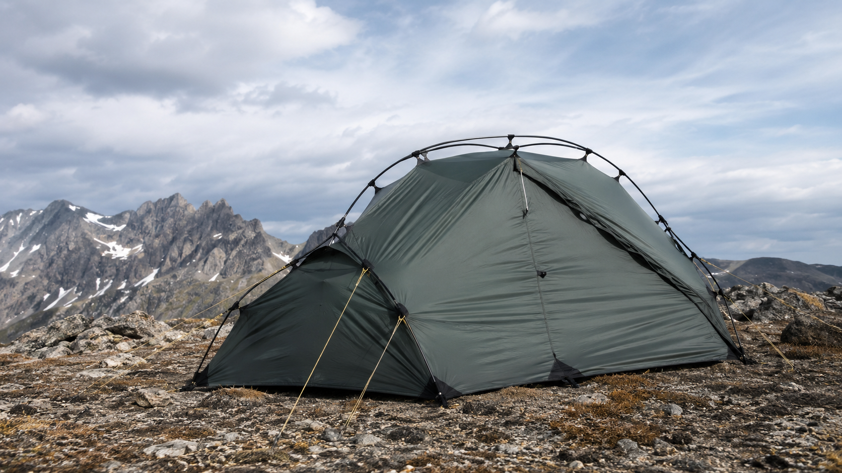 Crossed poles and taut guy lines reinforcing a mountain tent